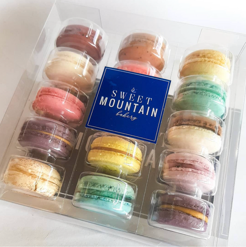 Box of assorted macarons with 'The Sweet Mountain Bakery' label.